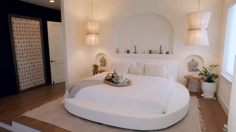 A round platform bed in a primary suite