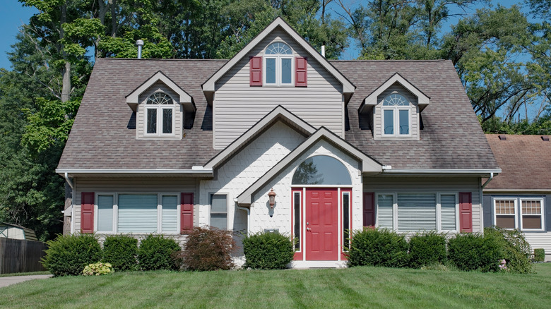 Tan house with red shutters