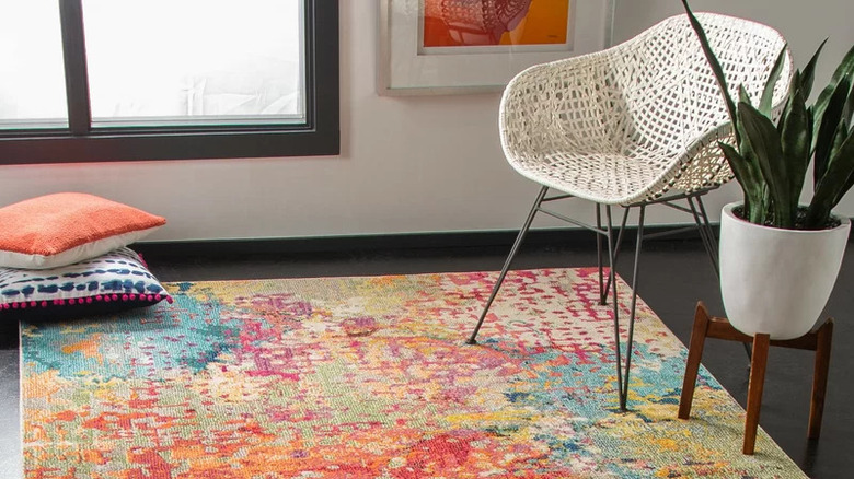 mottled rainbow rug on black floor