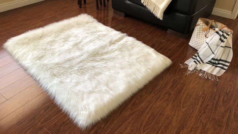 white shag rug on dark red hardwood