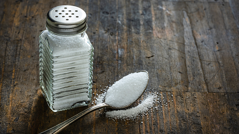 Salt shaker and tablespoon of salt