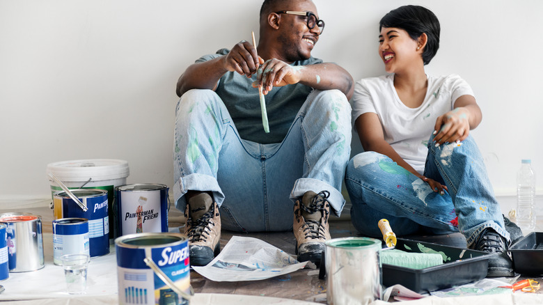 couple painting white room together