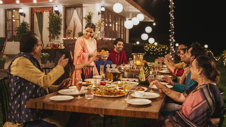 Family eating surrounded by outdoor lights