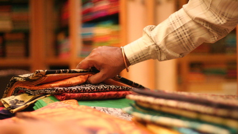 Someone looking through a stack of sarees