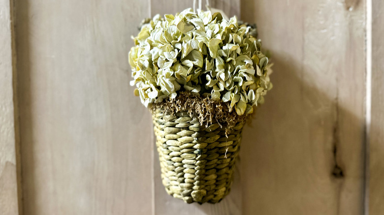 Hanging woven wall basket filled with flowers