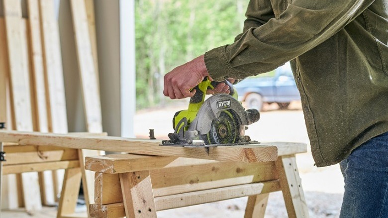 person cutting lumber with a circular saw