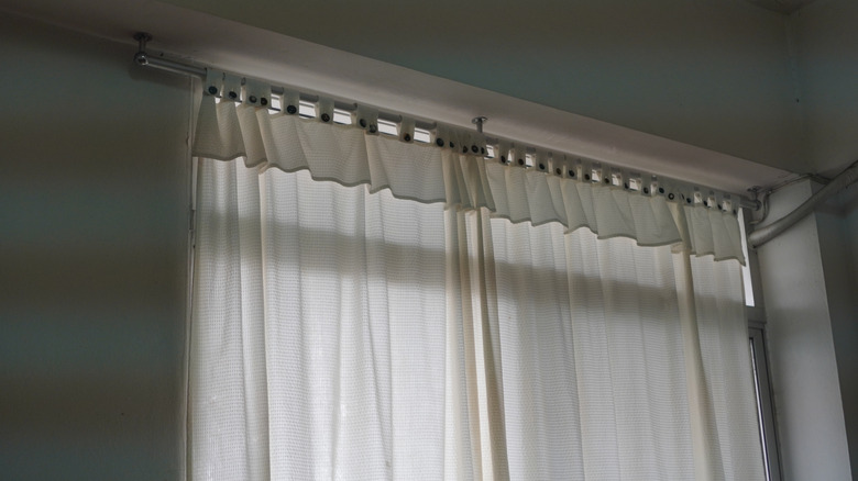 lightweight white curtains hanging from thin metal curtain rod