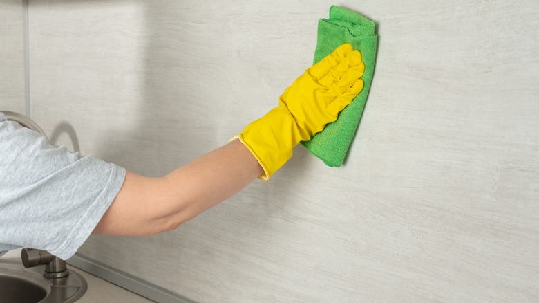 Cleaning kitchen wall with microfiber cloth