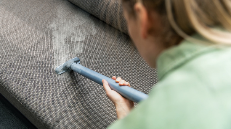 woman steam cleaning couch