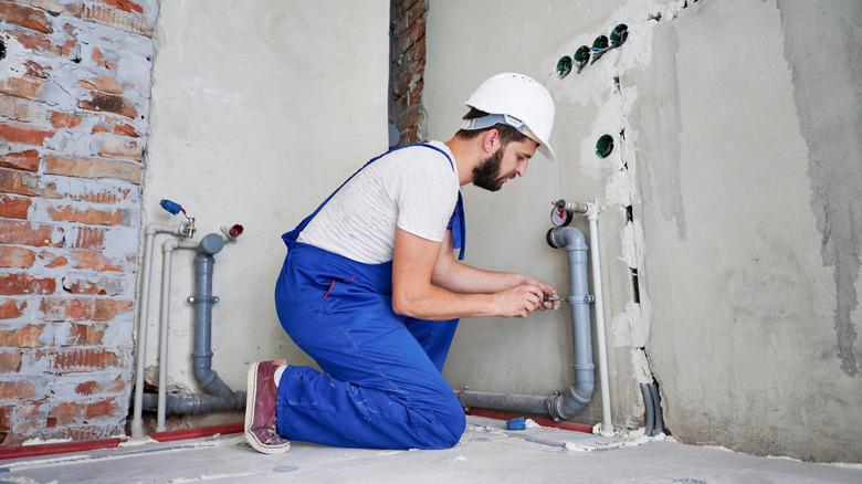 person doing rough in plumbing