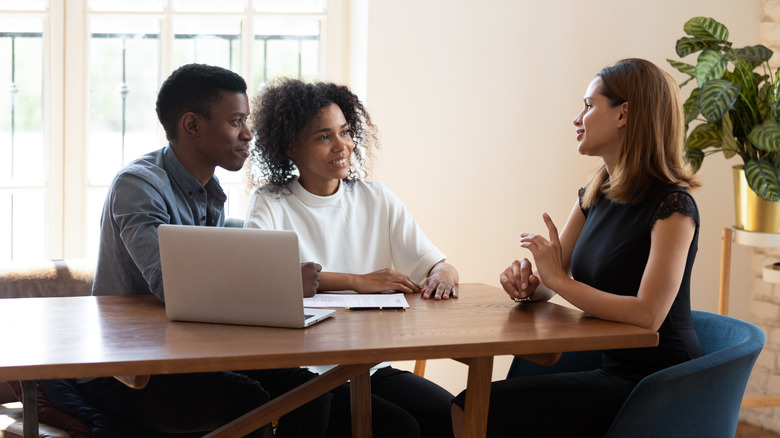 three people talking at table