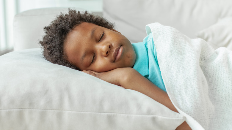 young boy sleeping in bed