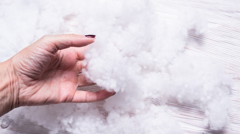 Woman handles fiberfill stuffing