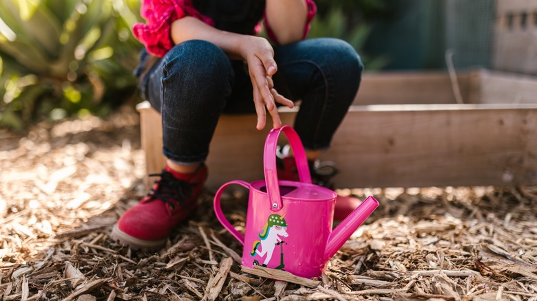 pink watering can with unicorn