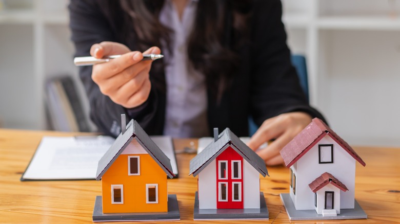 woman with three miniature houses