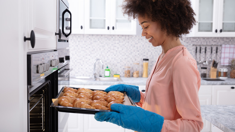 woman wearing oven mitts