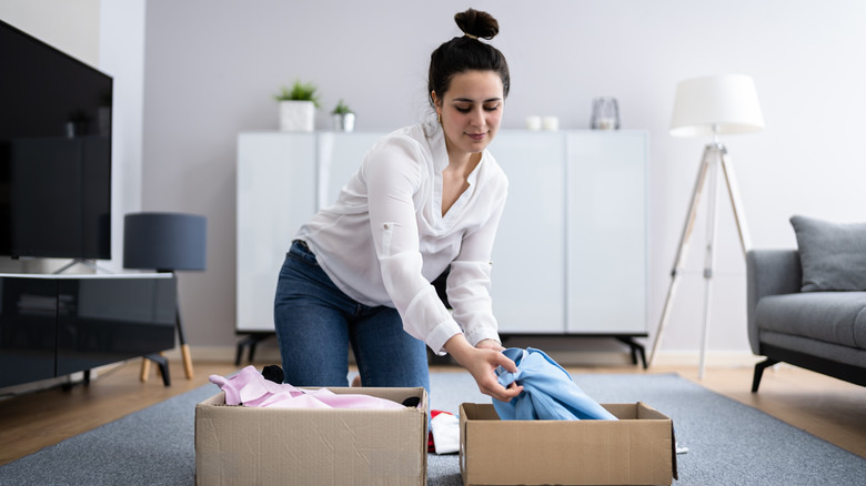 Woman sorting clothes into boxes