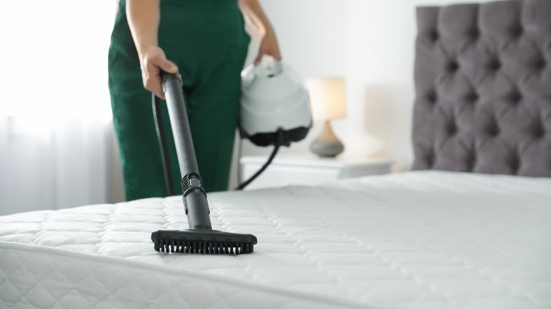 woman steam cleaning mattress