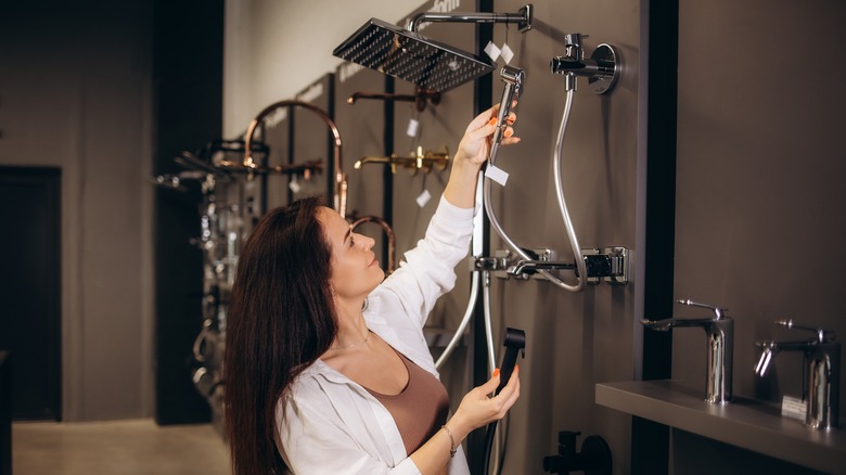 Woman looking at shower heads in store