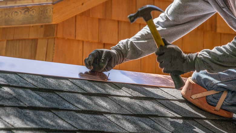 Person installing flashing on a roof