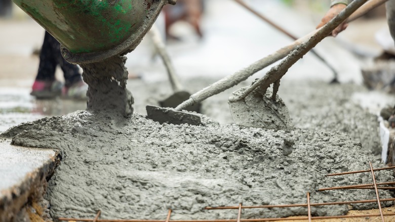 Shovels spreading wet concrete