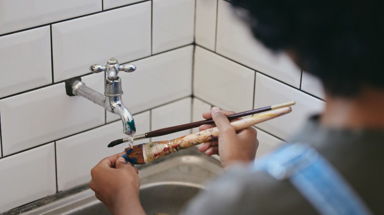 Person washing paintbrushes