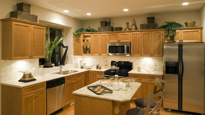 Large baskets and metal vases on top of cabinets