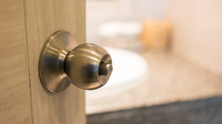 Shiny knob on door leading into bathroom