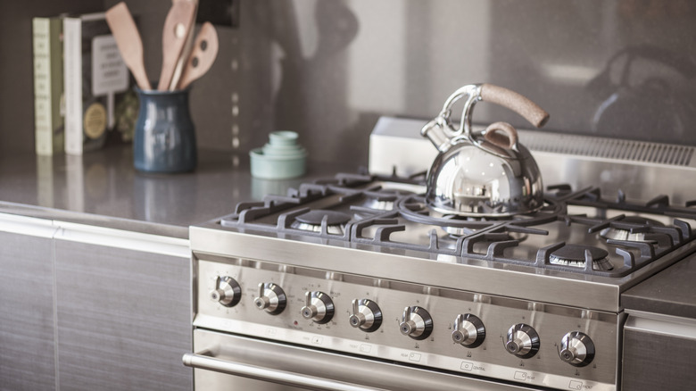 Stainless steel stove in a gray kitchen.