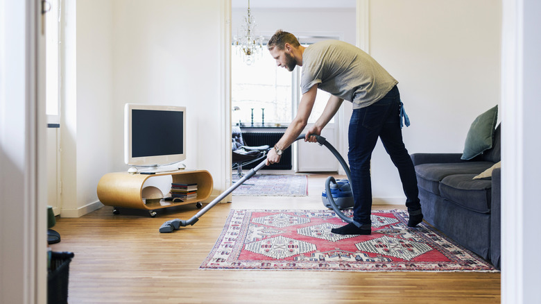 Man vacuuming a living room