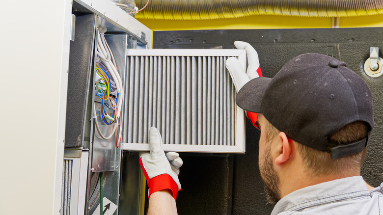 HVAC technician changes a dirty air filter in an HVAC system