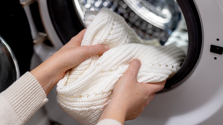 person putting small load in dryer