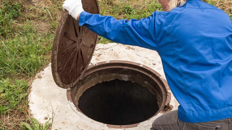 Plumber opening up a septic tank