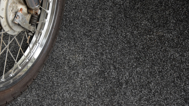 A motorcycle wheel on a carpeted floor