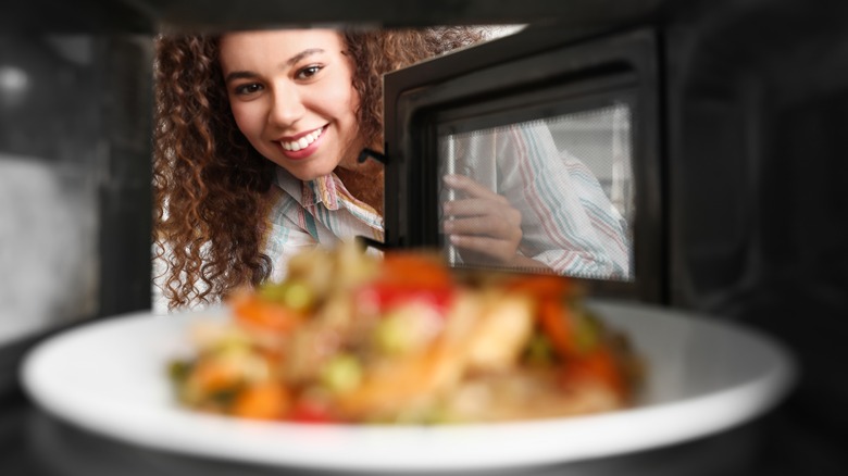 Woman looking into microwave