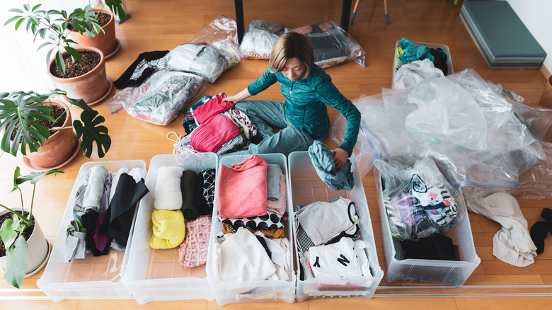 Woman organizing clothes into bins