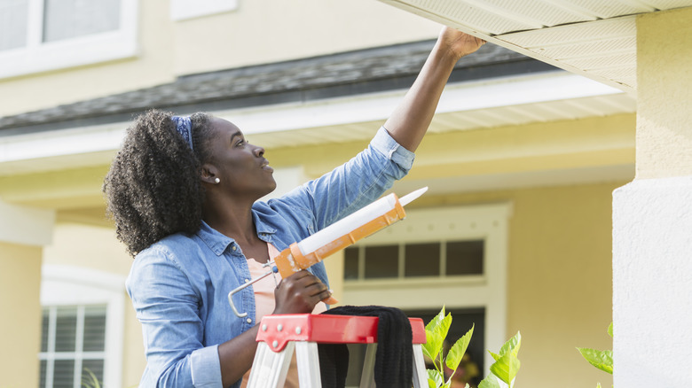 woman using caulk gun