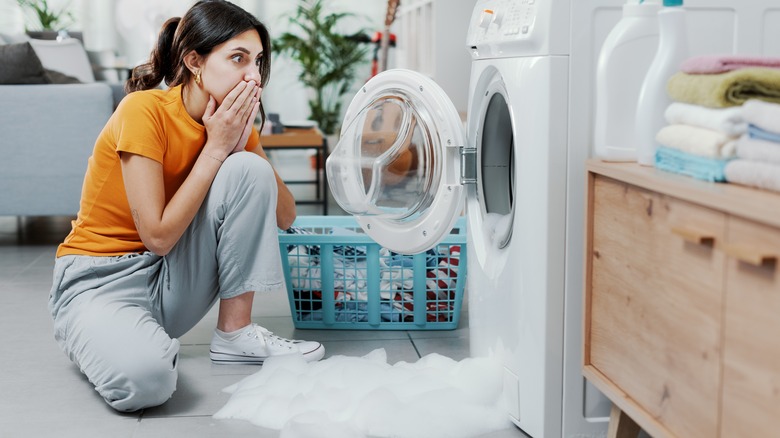 person looking at overflowing washer