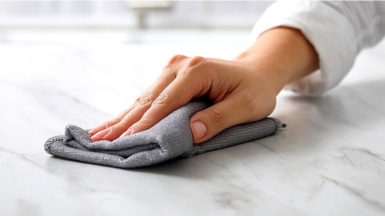 Hand cleaning countertop with cloth