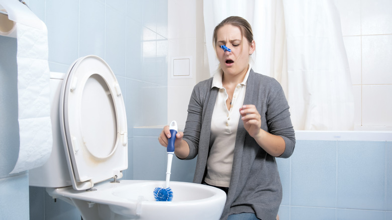 woman cleaning smelly bathroom