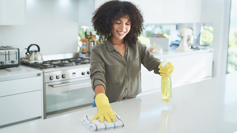 Woman cleans countertop with towel