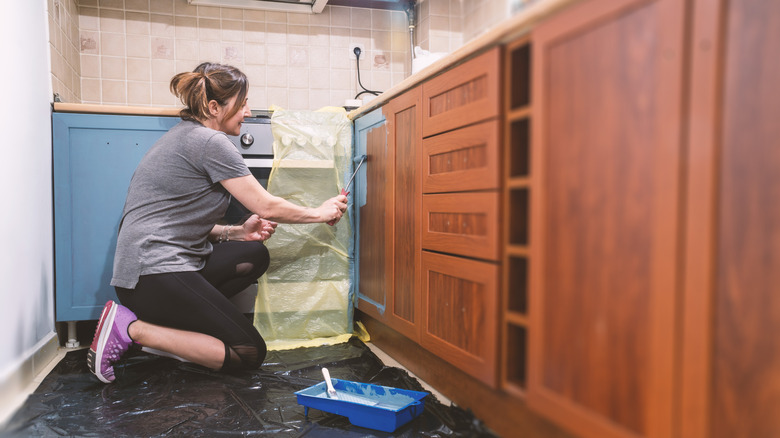 Woman painting kitchen cabinets