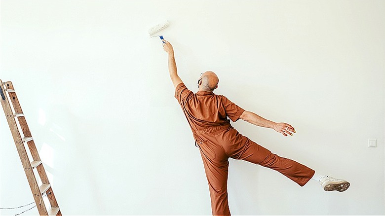 Person painting wall white