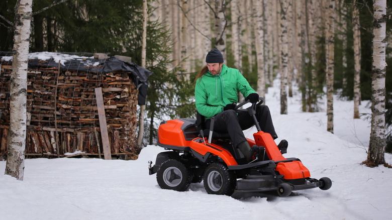 Man riding lawnmower in snow