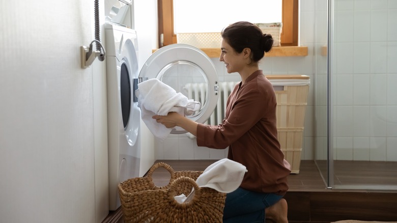 Woman putting washing into machine