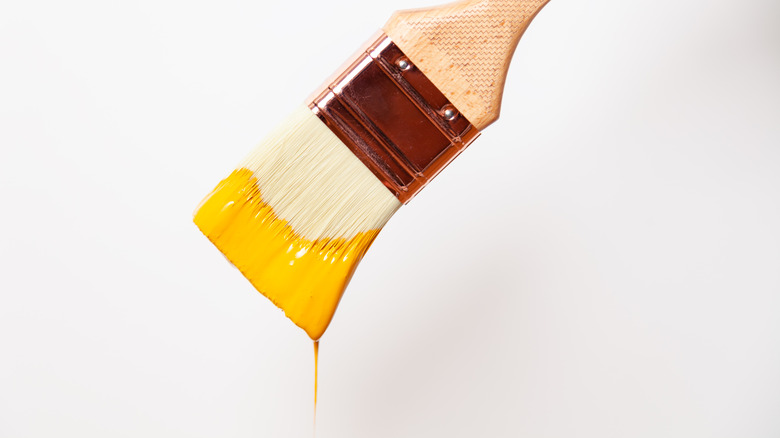 Paint brush dripping yellow paint