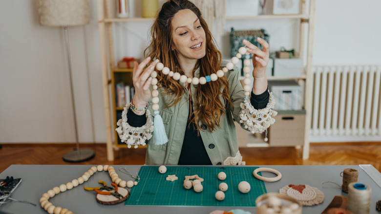 Woman holding white wooden beads