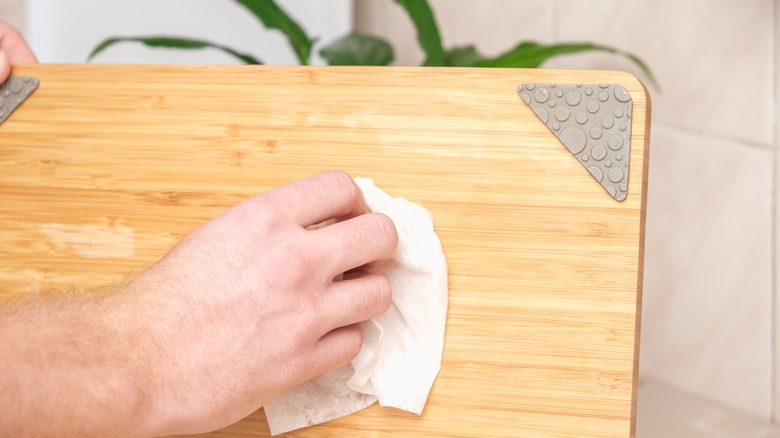 Man polishes wooden cutting board