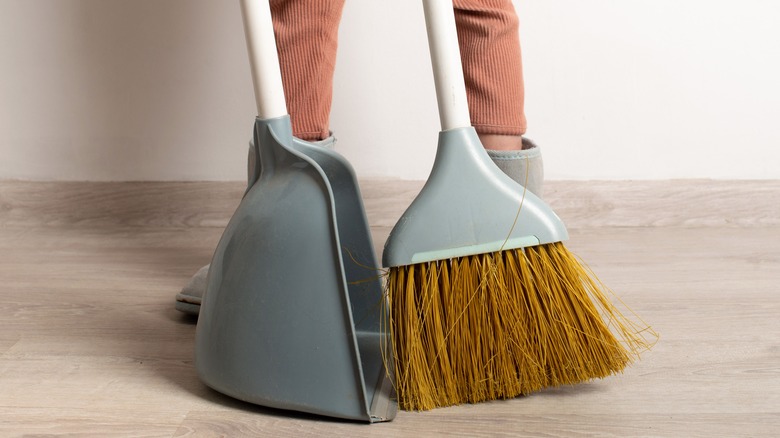 Person using broom and dustpan