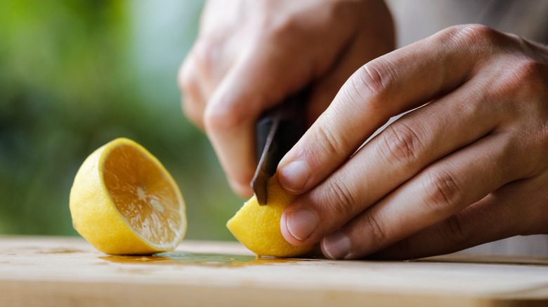 cutting a lemon into pieces 